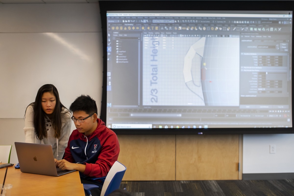Two students work in Maya to build virtual renderings