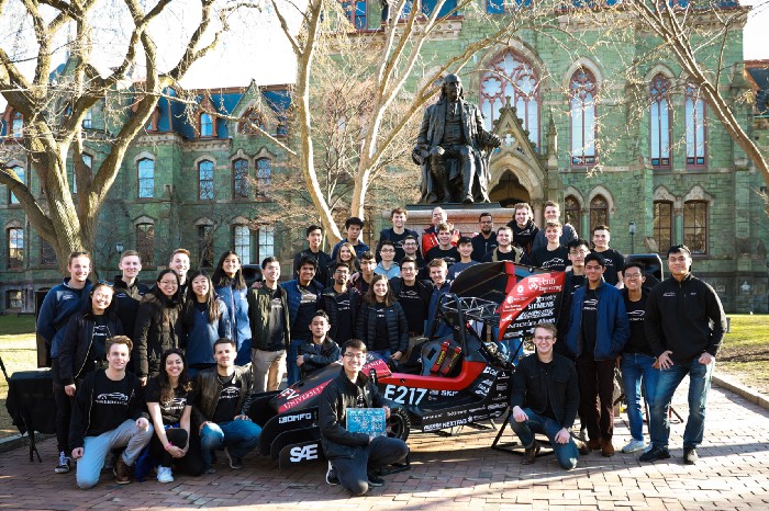 Penn Electric Racing team poses with race car outside of College Hall