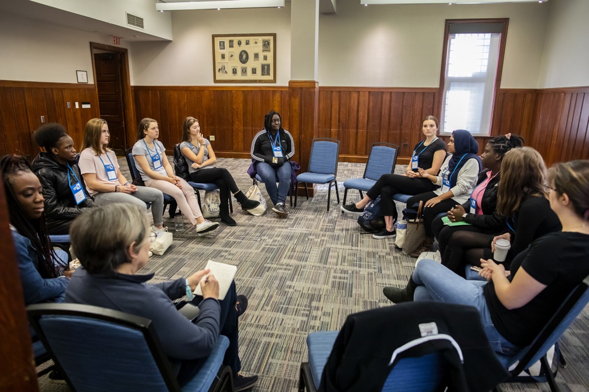 Women attending the GAINS conference sit in a discussion circle.