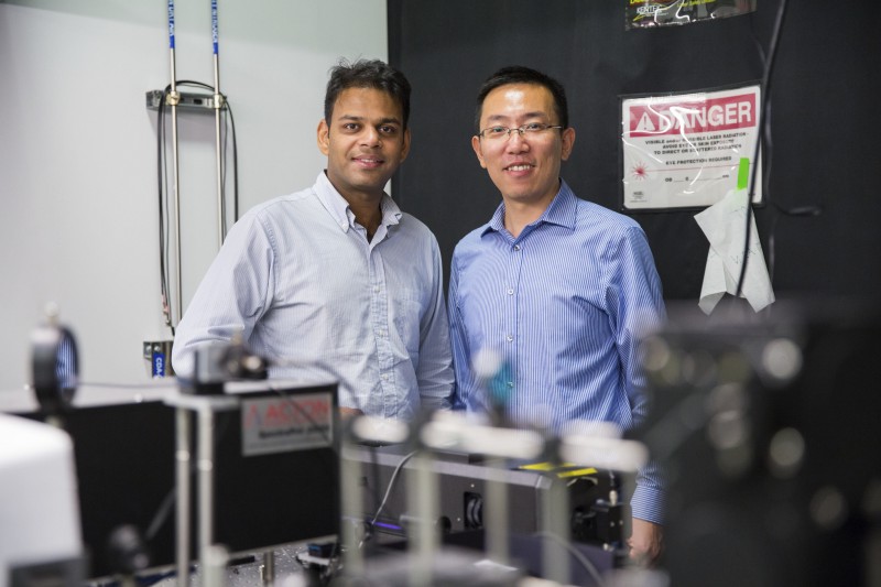 Ritesh Agarwal and Liang Feng pose among electrical engineering equipment.