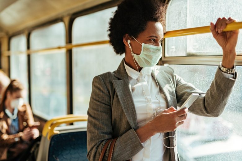 Woman rides public transit while wearing face mask