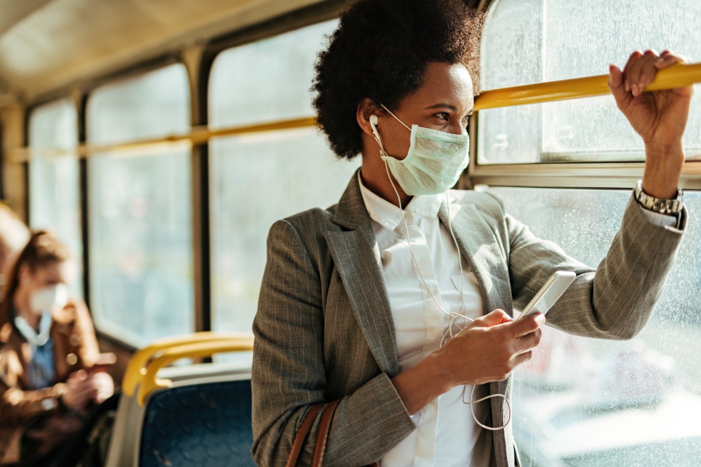 Woman rides public transit while wearing face mask