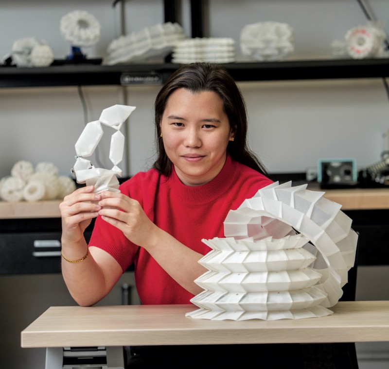 Professor Cynthia Sung holds up white robogami