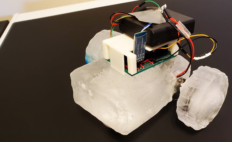 A rudimentary robot made out of blocks of ice with electronics attached.