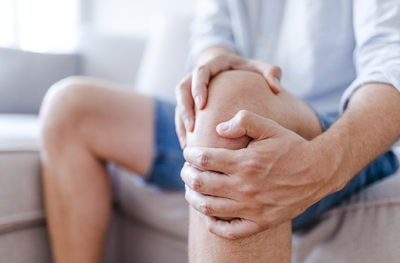 A man holding his knee in pain.