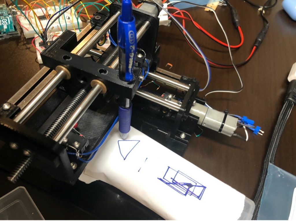 A plotter drawing a triangle.