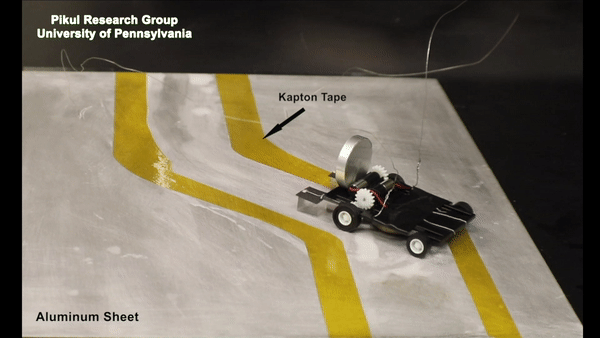 A wheeled robot autonomously navigates a path marked off by yellow tape.