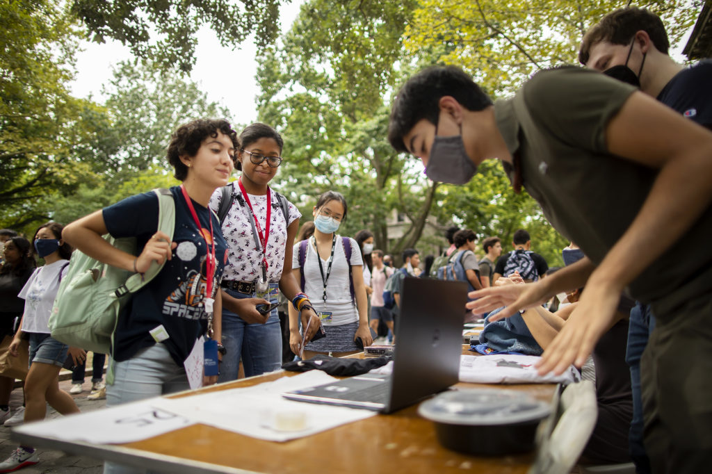 Two students watch a presentation on a laptop.