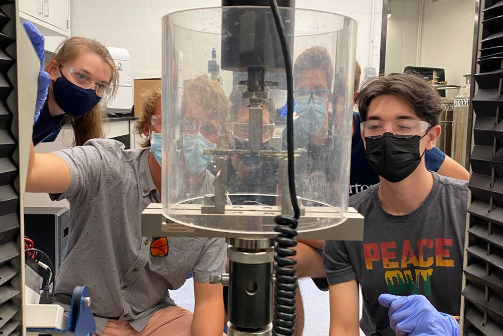 Students in masks look on at 