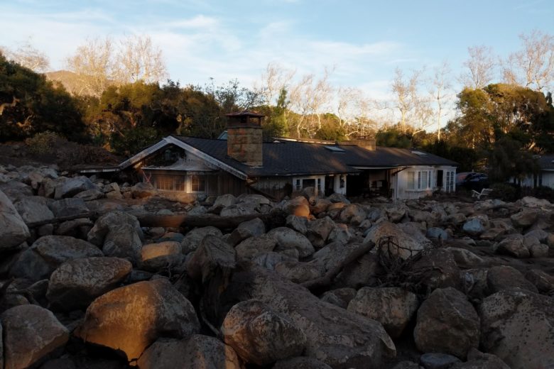 Picture of a house surrounded by boulders after a mudslide.