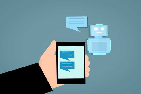 A robot with a speech bubble sits next to a smartphone