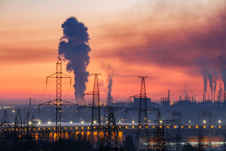 Industrial landscape with electric power lines, hydroelectric dam and metallurgical plants with smoke in the sky, Zaporizhzhia, Ukraine