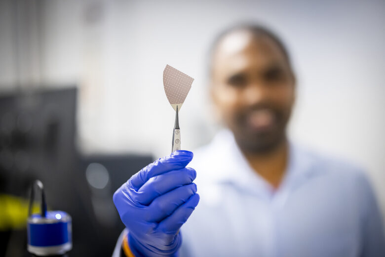 A picture of a memory resistant devise being held up by a pair of tweezers.