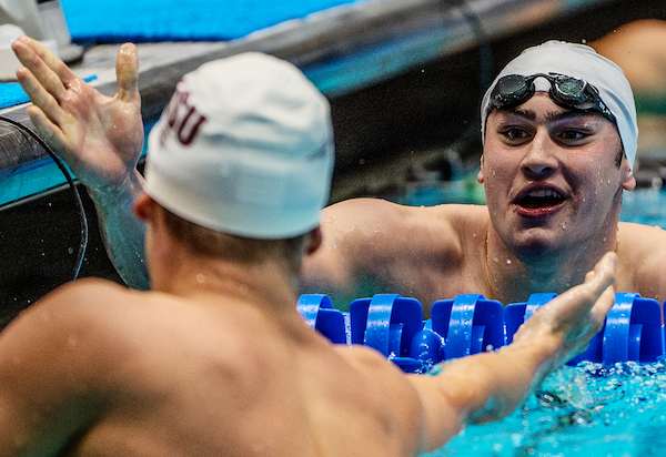 Matt Fallon high-fives Leon Marchand after the 200-yard breaststroke at the 2024 NCAA Championships