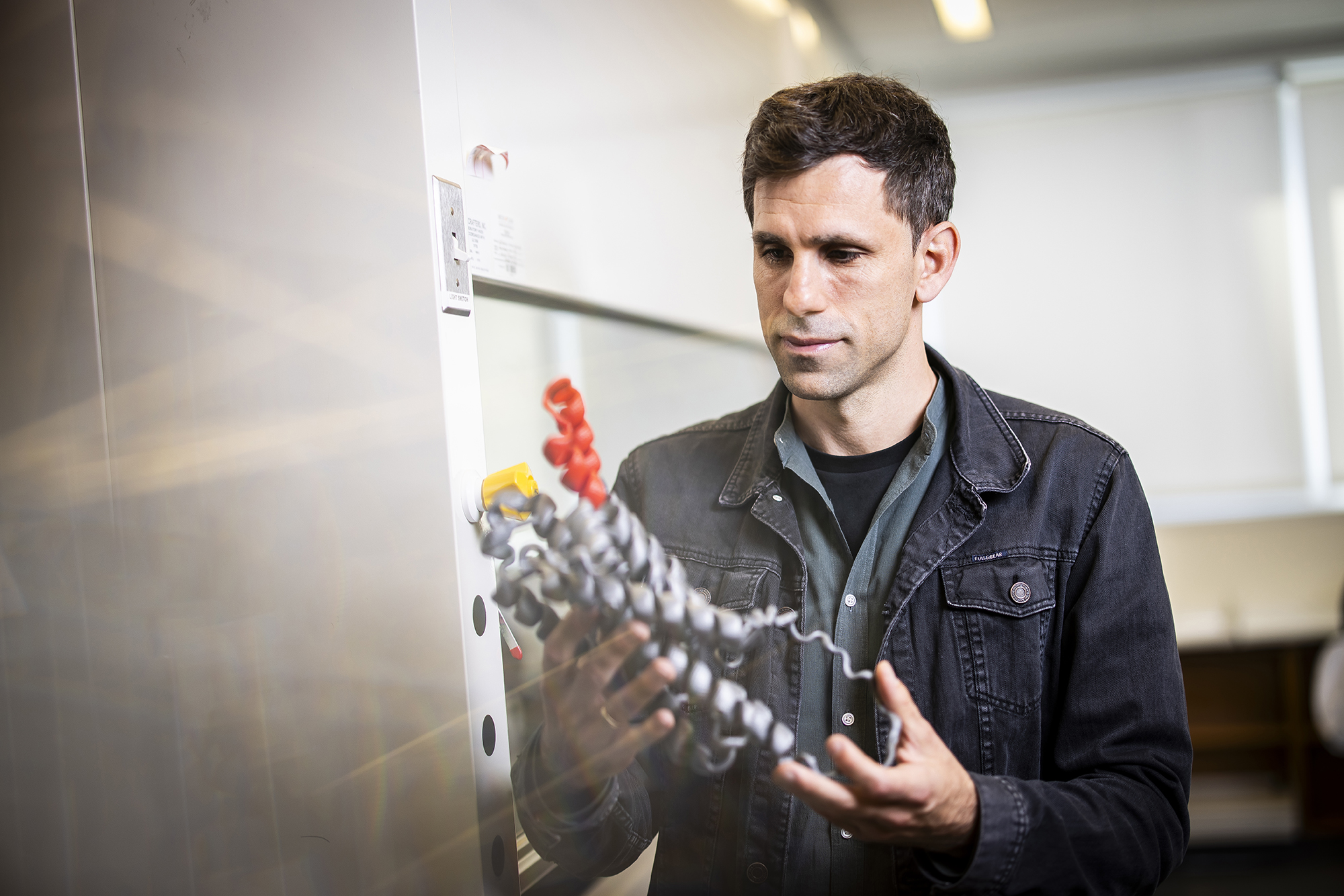 Cesar de la Fuente holding a 3D model of an antibiotic molecule.