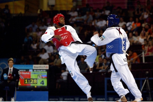 Chinedum Osuji represented Trinidad and Tobago at the 2004 Olympic Games in Athens. Here he kicks someone in the midst of a match while wearing protective gear.