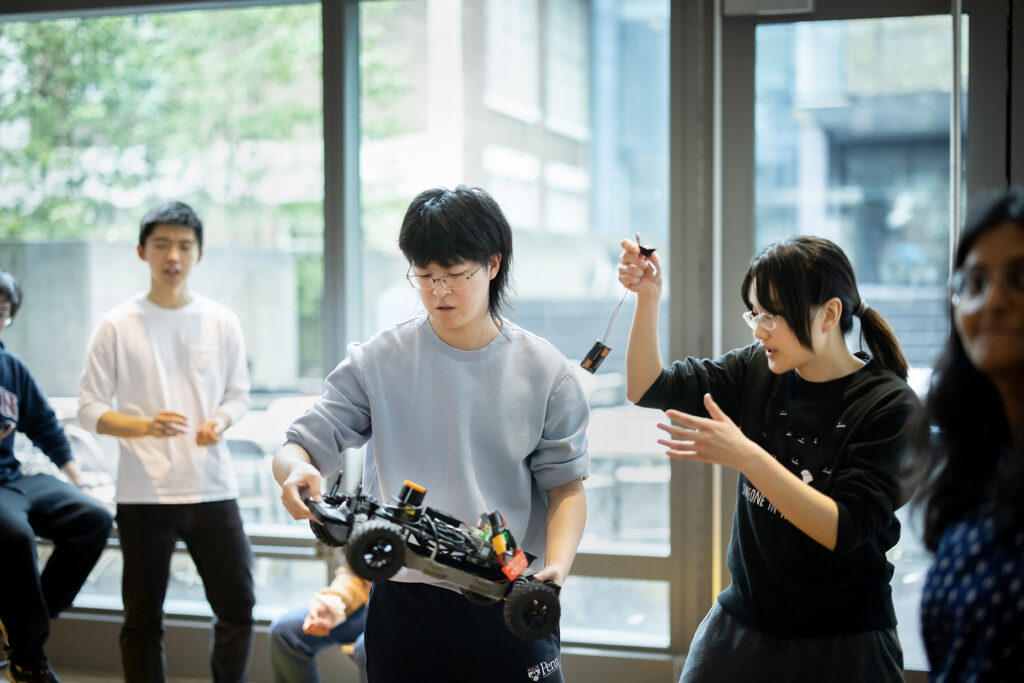 Engineering students displaying tiny racing cars