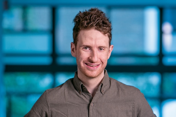 Jacob Gardner smiles while wearing a button-down shirt.