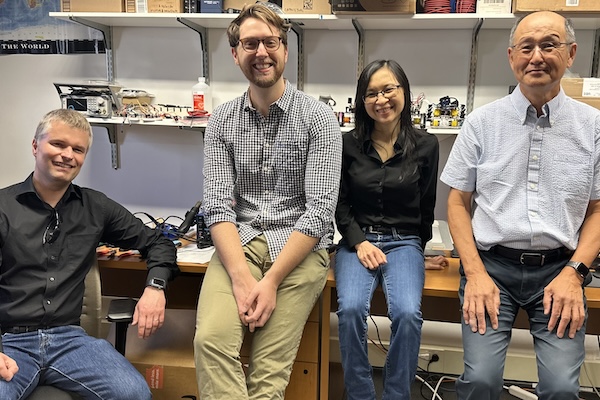 Four researchers sit side by side in a lab.