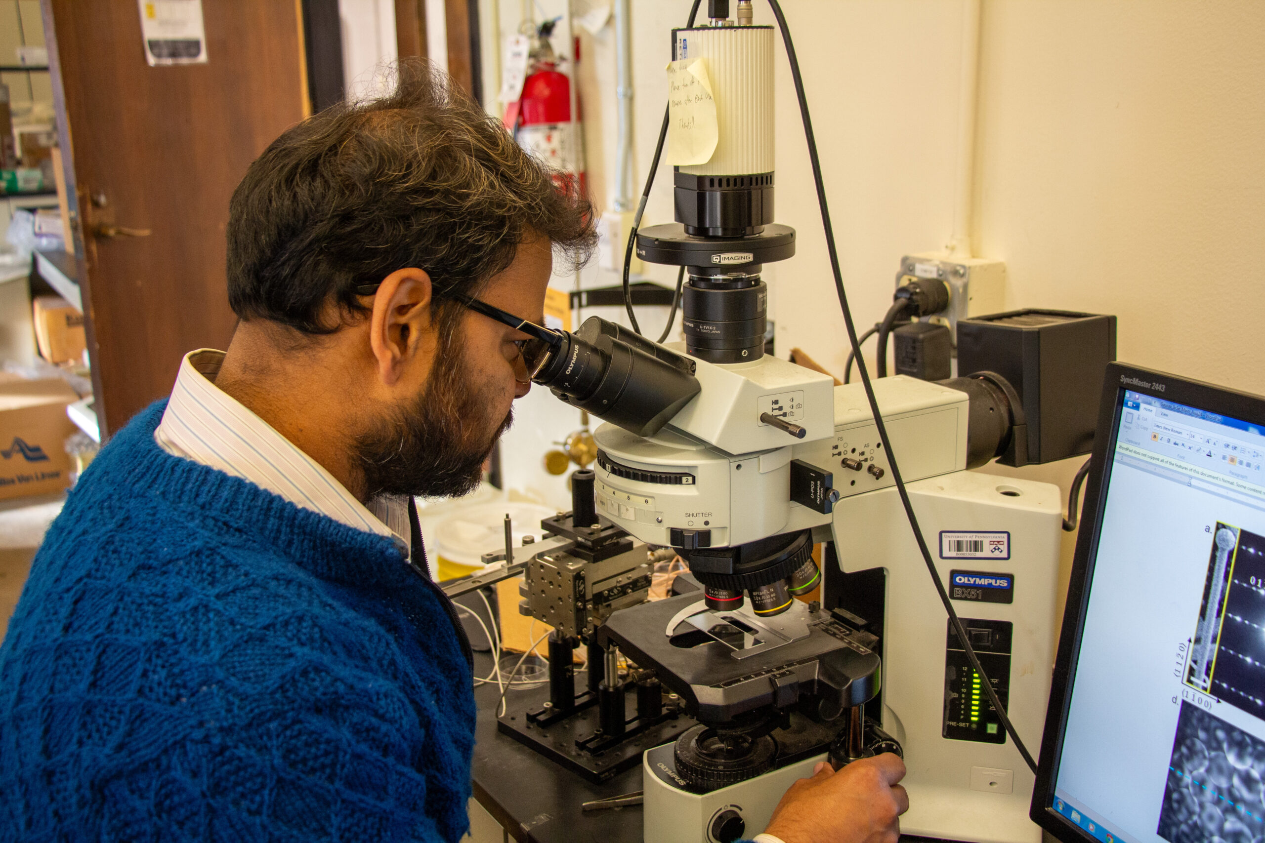 Ritesh Agrawal peers through a microscope.