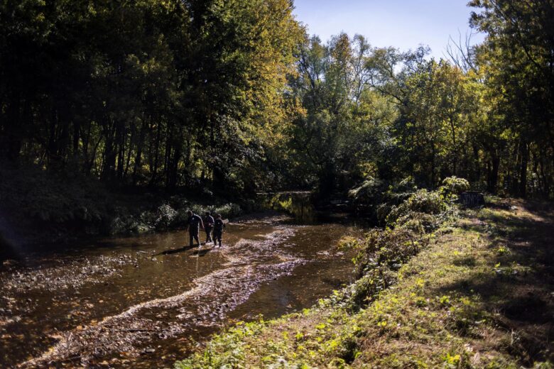 Picture of students walking in waders in a creek near Philadelphia.