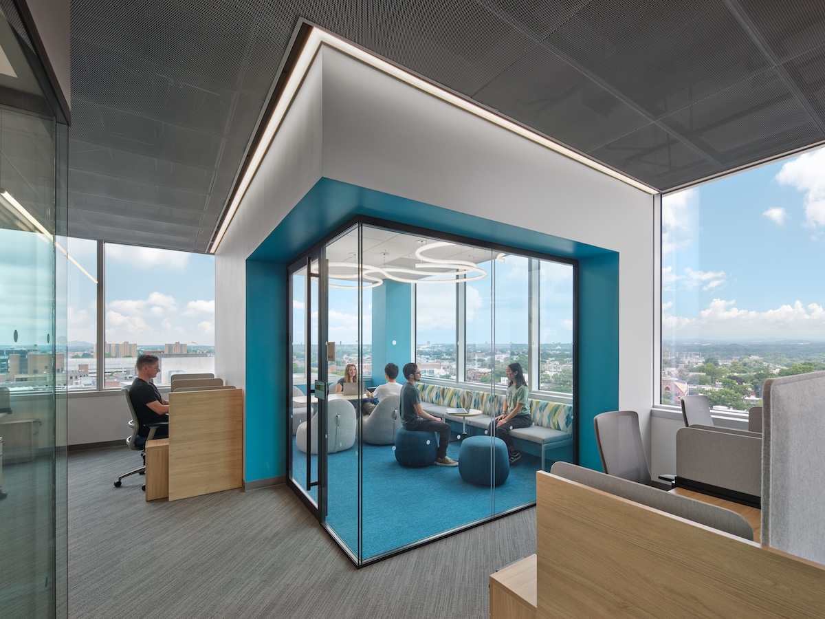 A group of researchers sit in a conference room with glass walls looking out at Philadelphia.