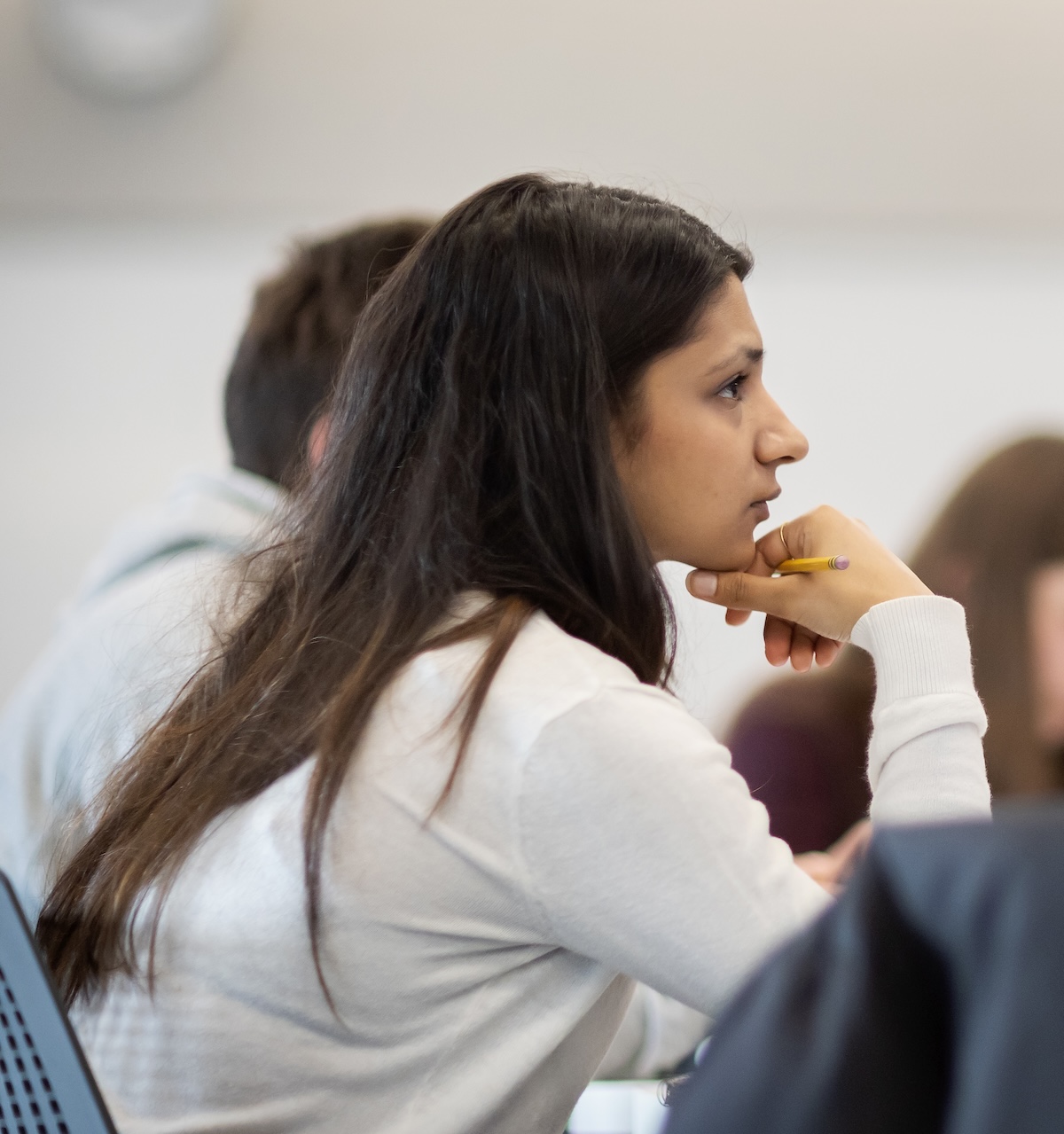 A young woman looks intently in profile while in class.