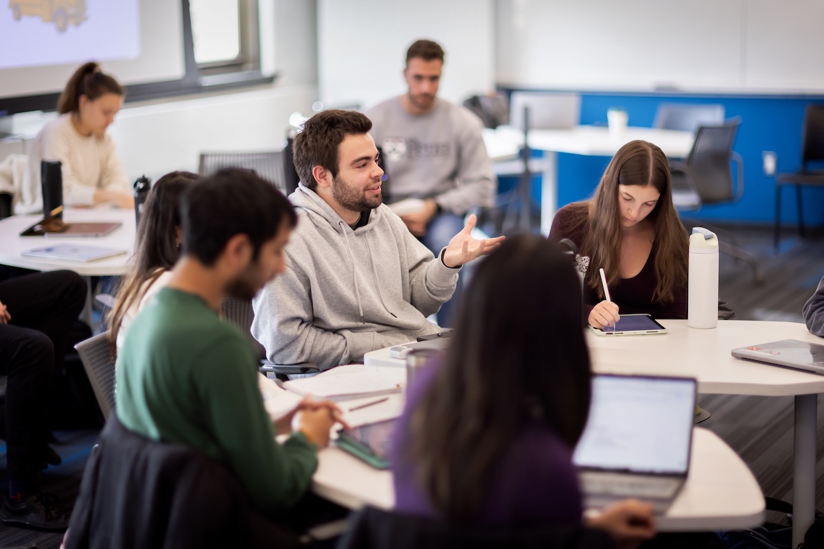 A group of students face the instructor in class.