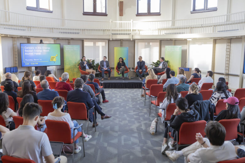 Image of a panel of Penn alumni on a stage doing a question and answer session with students.