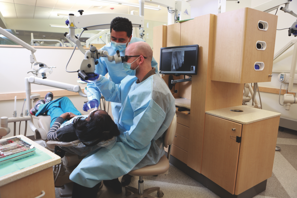 Two dentists working on a patient's dental care in a dental office.