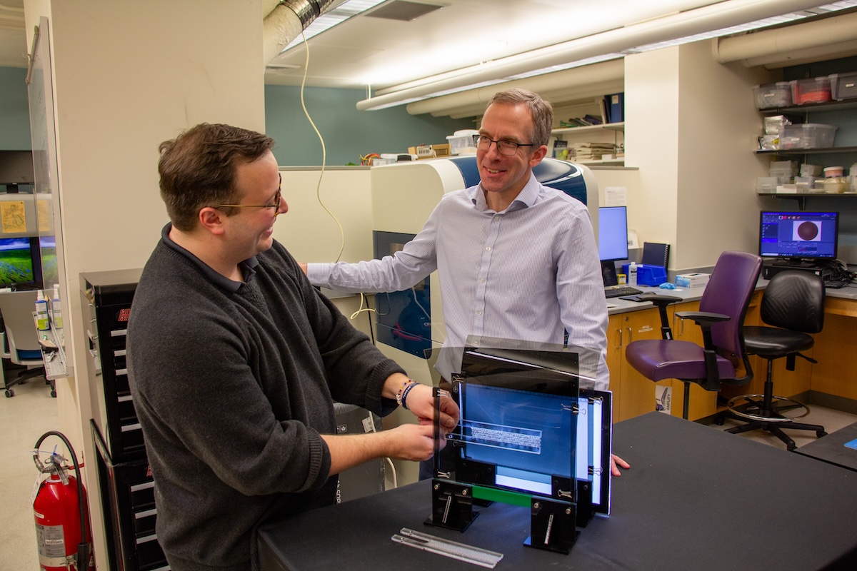 Fulco (right) and Turner (left), demonstrate the means by which they used light to assess the way mechanical stress affected the metamaterial. (Credit: Bella Ciervo)