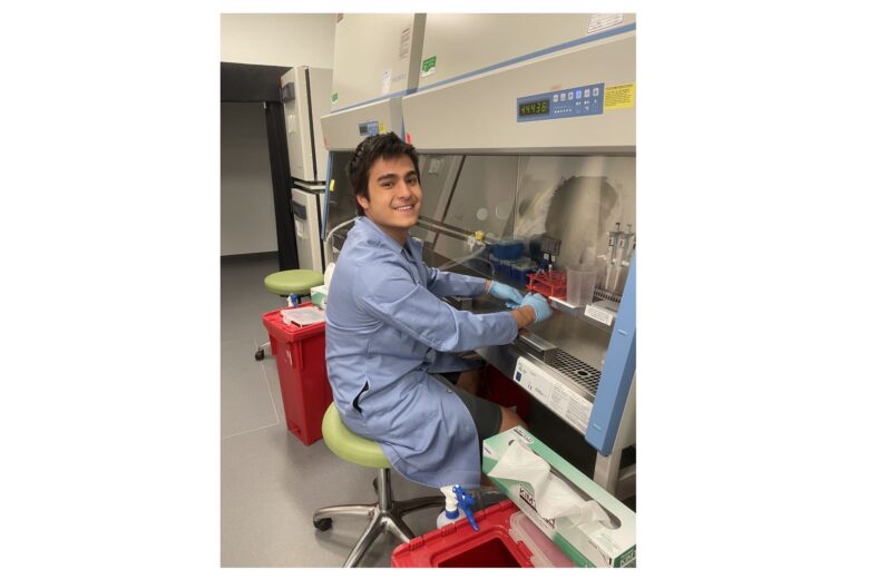 A picture of male student Ben Nachod ('26), a Bioengineering major, sitting down on a chair working in a lab.