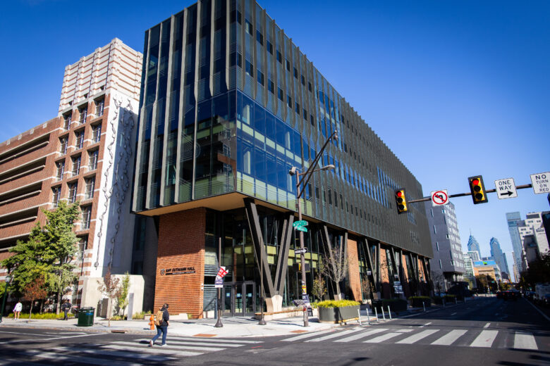 An exterior picture of Amy Gutmann Hall, a glass and timber 6 floor structure at the corner of 34th Street at the University of Pennsylvania.