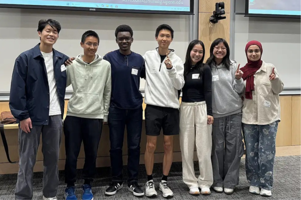 Picture of seven students in front of a screen celebrating their datathon win.