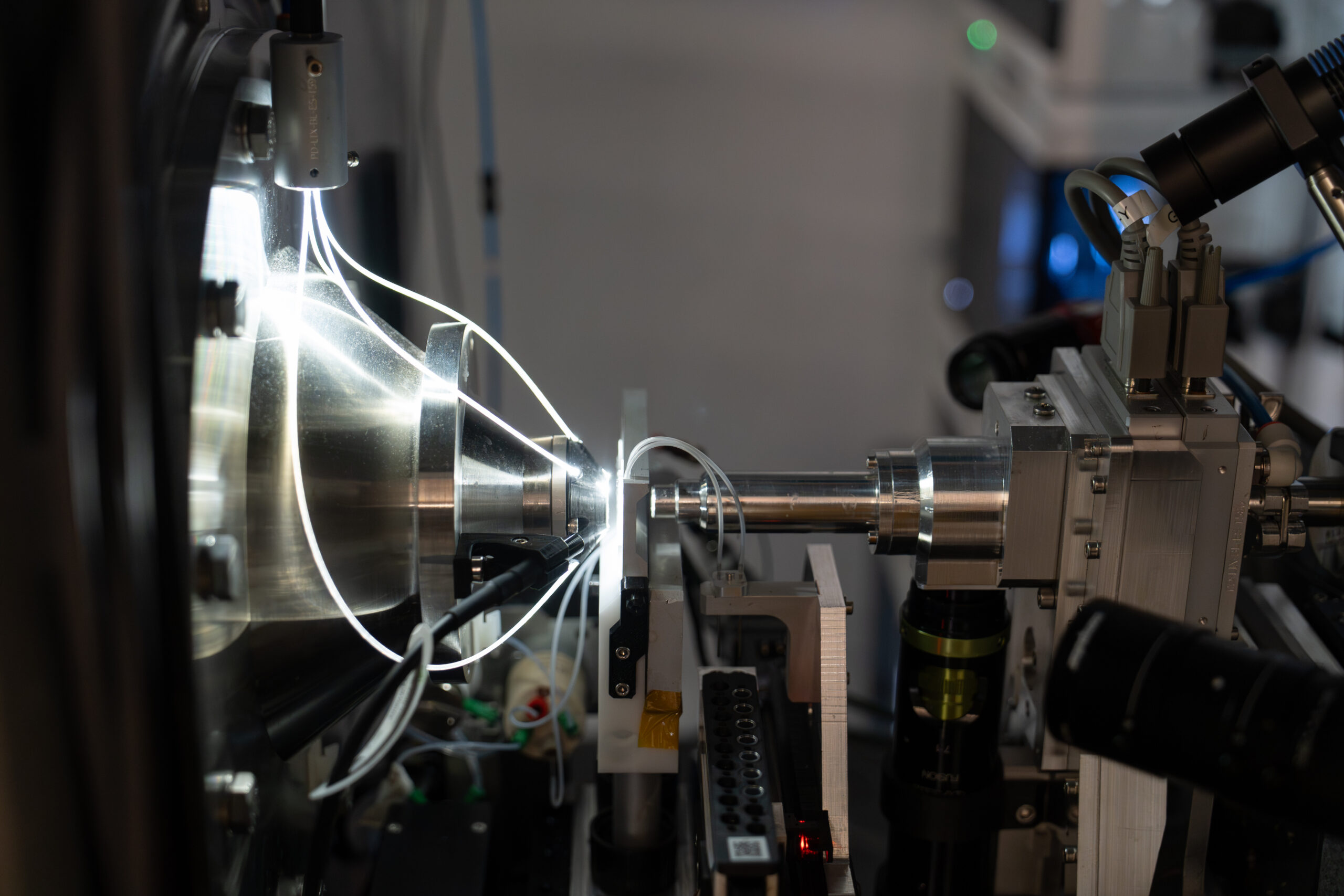 A close-up image of a series of brightly lit wires entering a cylinder.